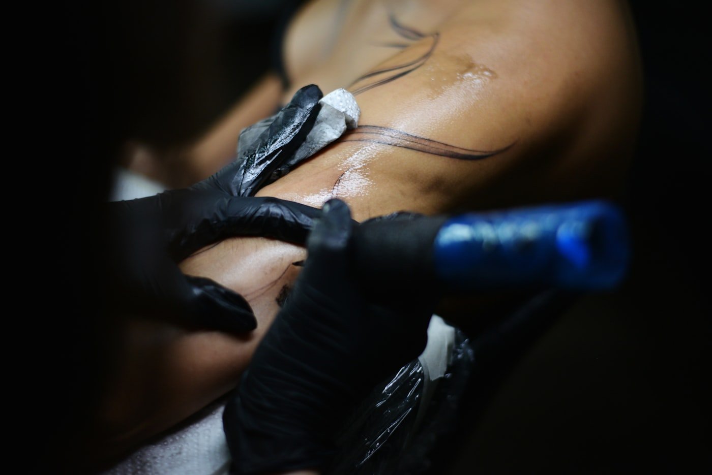 Detailed black and grey tattoo being applied on a client's back