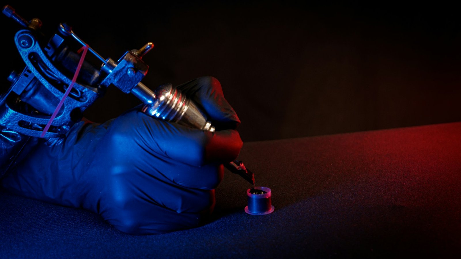 Close-up of a tattoo artist's hand working with a tattoo machine